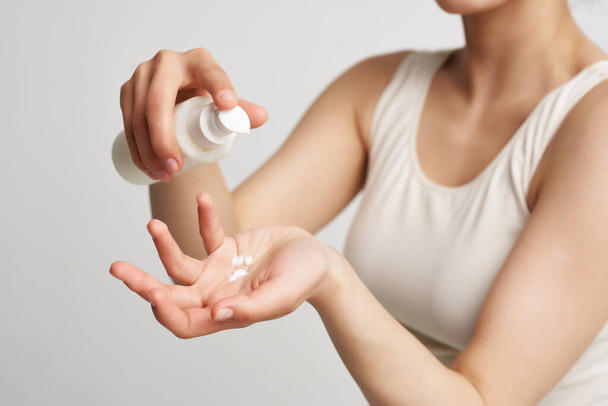 vrouw in witte tank top huid lotion gezondheid verjonging - Foto, afbeelding