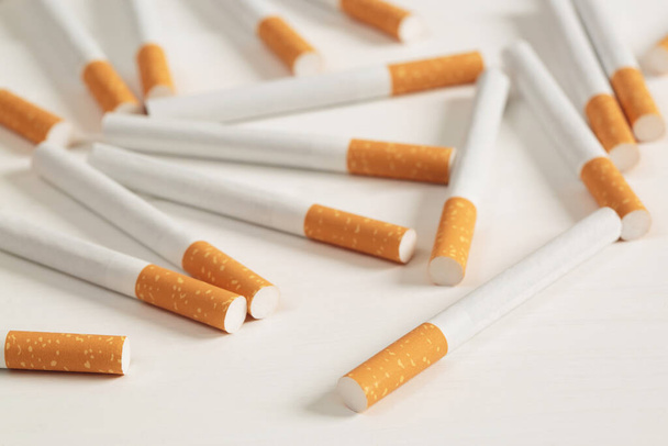 imagen de varios cigarrillos hechos comercialmente sobre fondo blanco. o concepto de campaña de no fumadores, vista superior del patrón de tabaco. - Foto, Imagen