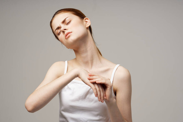 γυναίκα σε λευκό t-shirt ρευματισμούς βραχίονα προβλήματα υγείας απομονωμένο υπόβαθρο - Φωτογραφία, εικόνα