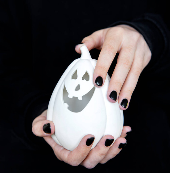 Fijne Halloween. Vrouwelijke handen met grappige pompoenen op zwarte achtergrond. Manicure met zwarte nagellak - Foto, afbeelding