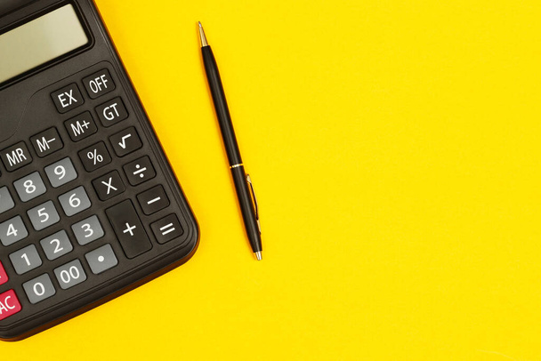 calculator with pen for accountant on yellow background - Photo, Image