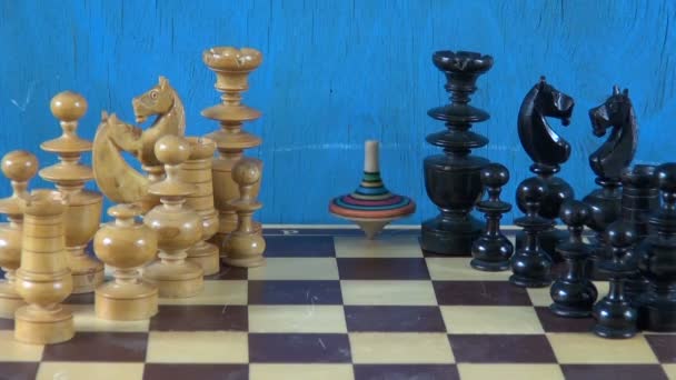 chess pieces on chessboard and colorful whirligig humming-top - Footage, Video