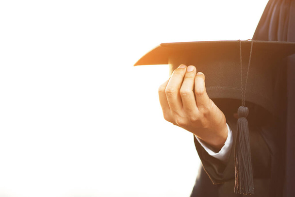 close up people show hand hold show hat in background School building. Shot of graduation cap during Commencement University Degree Concept , Celebration Education Student Success Learning Concept. - Photo, Image