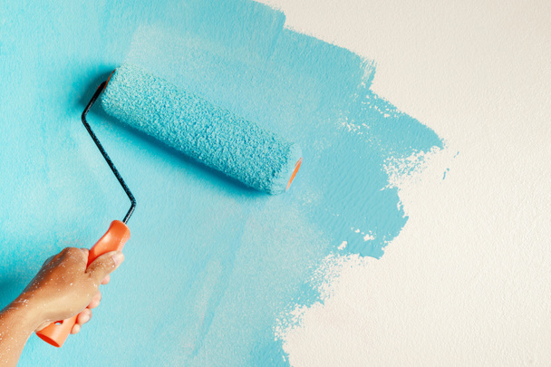 Pintura del pincel del rodillo, pintura del trabajador en la pared superficial Pintura apartamento, renovando con pintura de color azul. - Foto, Imagen
