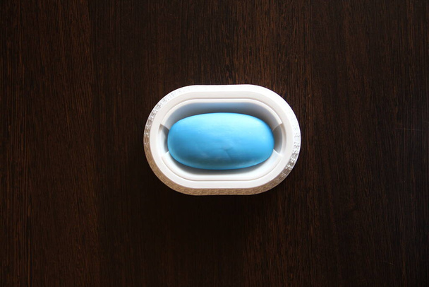 Jabón en un plato de jabón sobre el fondo de madera - Foto, Imagen