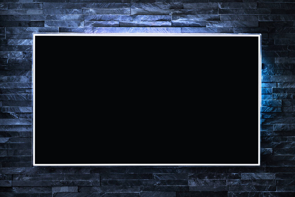 Телевізійний екран на стіні вночі в темряві з світлодіодним світлом. Телевізор і плоский смарт-монітор відображаються на синьому цегляному фоні. Сучасний футуристичний горище вітальня або лаунж. Порожній чорний екран
. - Фото, зображення