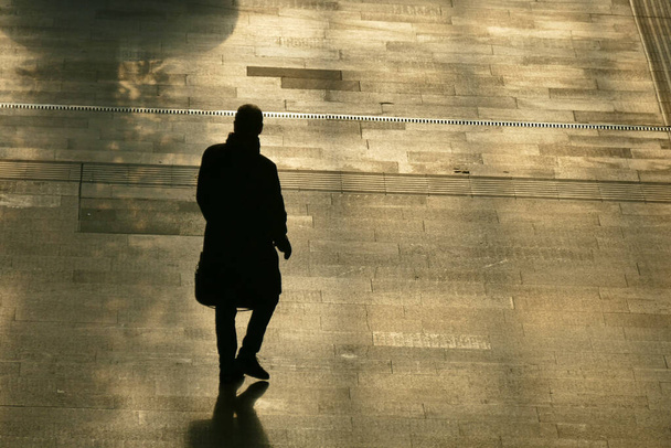 The silhouette of the lonely man walking on the street. - Photo, Image