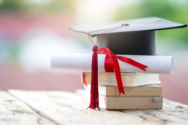 A closeup shot of a graduation cap and diploma degree certificate on a table - Φωτογραφία, εικόνα