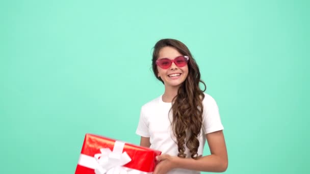 щаслива щаслива дитина в сонцезахисних окулярах тримає подарункову коробку, з днем народження
 - Кадри, відео