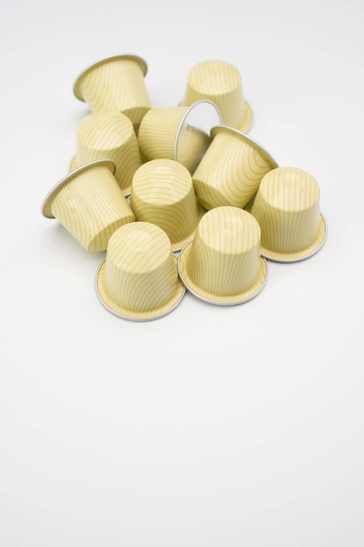 A vertical shot of white espresso capsules a white background - 写真・画像