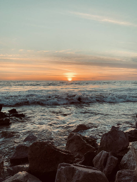 A vertical shot of a beautiful seascape at scenic sunset - Фото, изображение