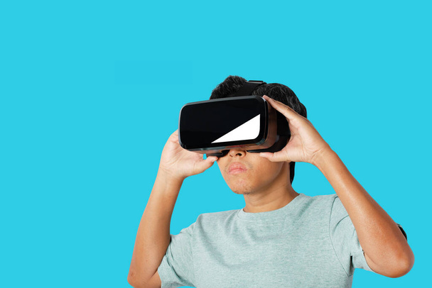 Młody człowiek korzystający z zestawu słuchawkowego wirtualnej rzeczywistości. VR, przyszłość, koncepcja technologii online. izolowany na niebieskim tle. ścieżki wycinania. - Zdjęcie, obraz