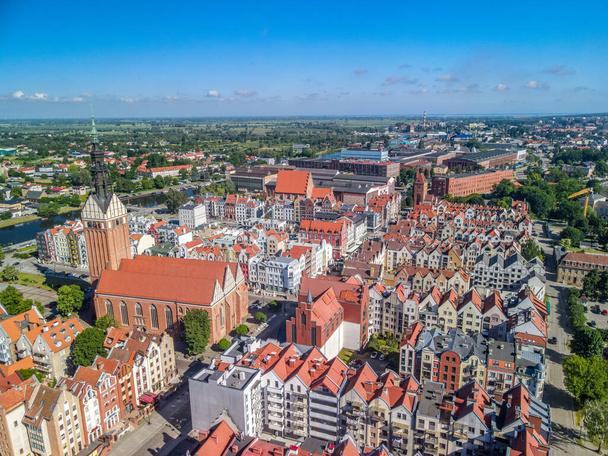 ELBLAG, POLAND - Jun 17, 2021: An aerial shot of an old town Elblag, Poland, full of houses with red roofs, and a long river - Foto, afbeelding