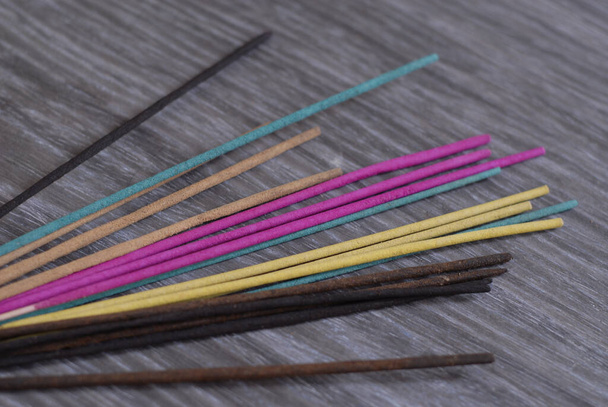 A heap of colorful incense sticks on a gray wooden table - Fotografie, Obrázek