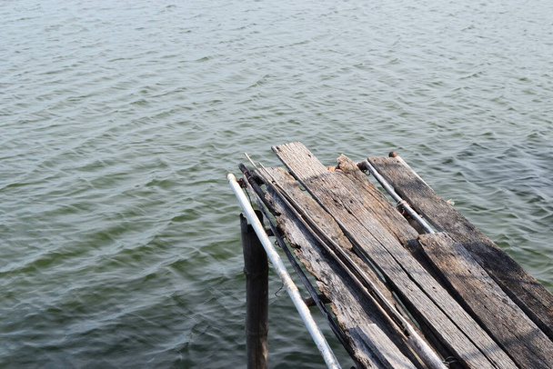 Muelle o viejo puente de madera que se extiende en el lago, Amplio y tranquilo agua - Foto, imagen