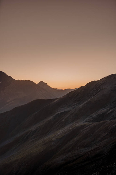 A beautiful view of the sun setting behind the mountain chain - Фото, зображення