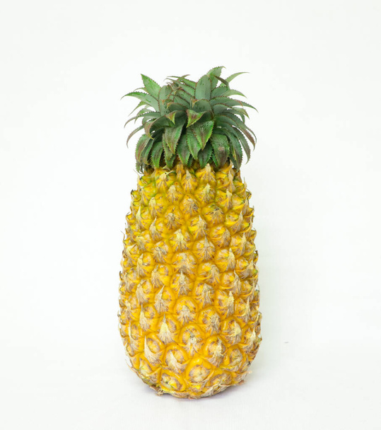 een rijpe ananas geïsoleerd op een witte achtergrond - Foto, afbeelding