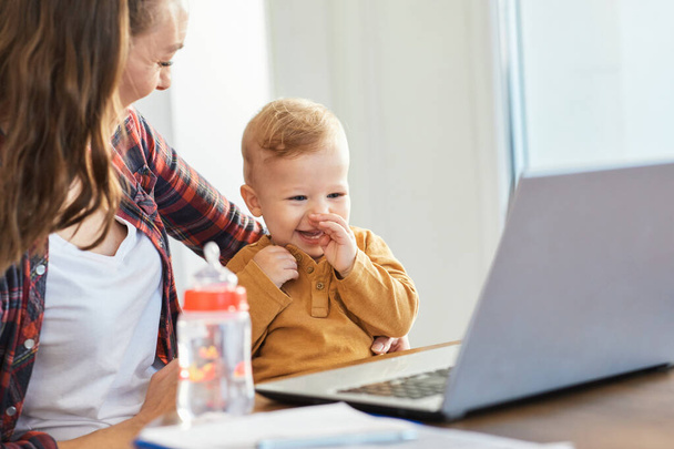 anya baba laptop számítógép gyermek nő dolgozó üzleti szülő anya család - Fotó, kép