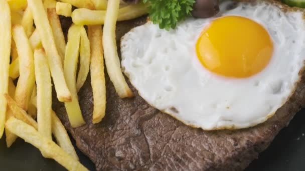 Portugal dish Bitoque made from beef steak with a fried egg, rice, french fries and vegetables - Footage, Video