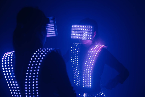Two sexy disco dancers move in UV costumes. Parties and dances. - 写真・画像