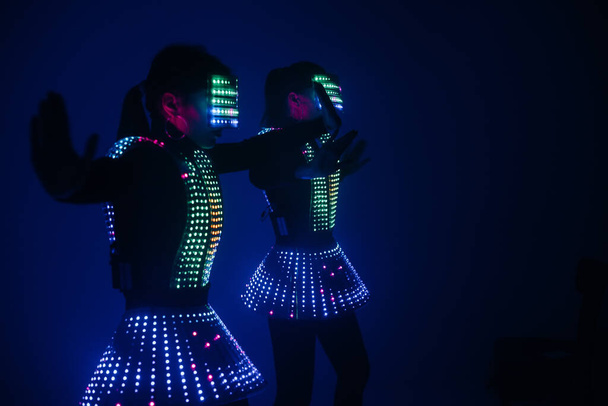 Two sexy disco dancers move in UV costumes. Parties and dances. - Foto, Bild