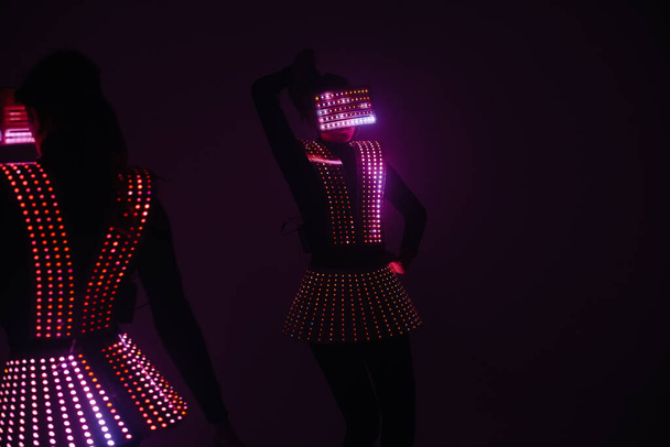Two sexy disco dancers move in UV costumes. Parties and dances. - Fotoğraf, Görsel