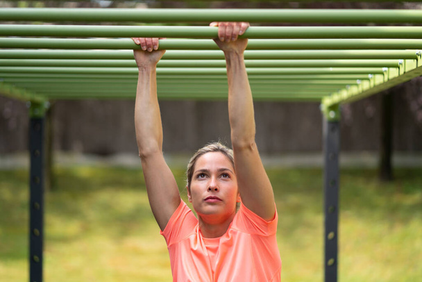 Femme blonde forte dans une salle de gym extérieure faisant de l'exercice - Photo, image