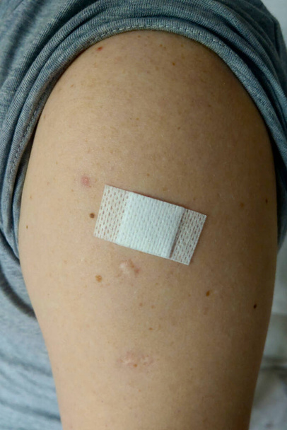 Ihmisen käsi rokotuksen jälkeen Covid 19, suositeltava rokotuskonsepti, rokotus, rokotettu potilas. Toimenpiteet, joiden tarkoituksena on ottaa käyttöön antigeenispesifisiä komponentteja kehoon - Valokuva, kuva