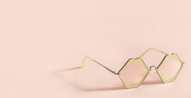 Pembe arkaplanda dudak şeklinde pembe güneş gözlükleri ve fotokopi alanı  - Fotoğraf, Görsel