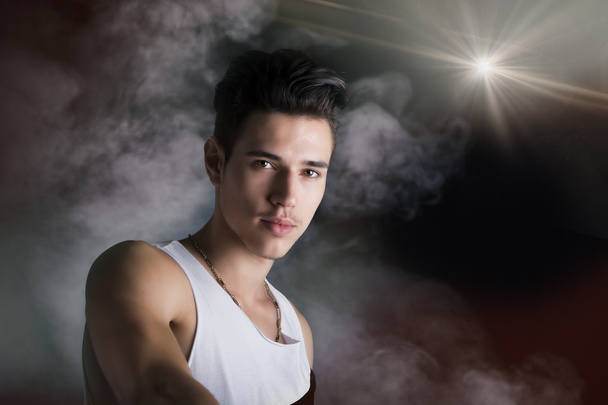 Young man against a moody cloudy background - Foto, imagen
