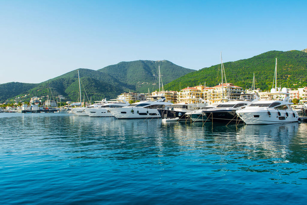 Вид на пристань для яхт в Порто Черногория с прибрежными резиденциями и красивой набережной - Фото, изображение