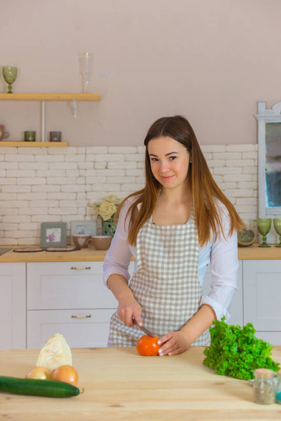 kaunis nuori nainen valmistelee terveellistä ruokaa keittiössä. ruokavalion ja laihtumisen käsite - Valokuva, kuva