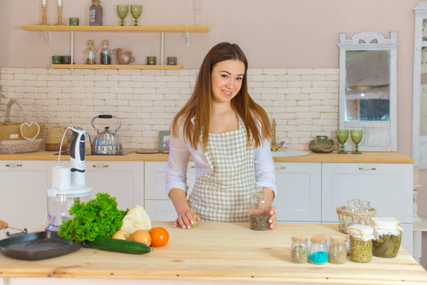 красивая молодая женщина готовит здоровую пищу на кухне. концепция диеты и потери веса - Фото, изображение