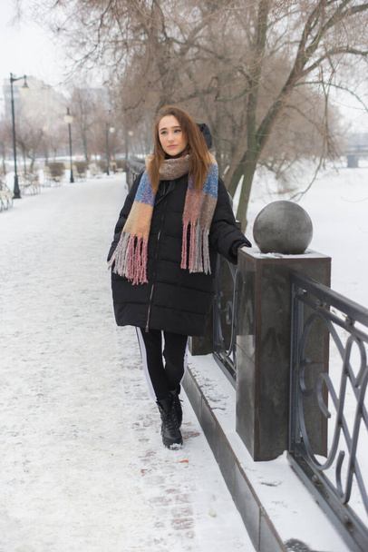 beautiful girl walks in the winter in warm clothes outdoors - Fotografie, Obrázek