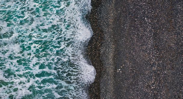 Dramatyczne fale burzowe z białą pianką morską nad czarną piaszczystą plażą, antenowa struktura morza - Zdjęcie, obraz