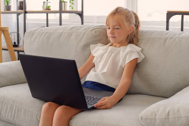 Πρώτη μέρα στο σχολείο. Χαριτωμένο και χαρούμενο μικρό κορίτσι παιδιά που χρησιμοποιούν φορητό υπολογιστή, μελετώντας μέσω του online συστήματος e-learning - Φωτογραφία, εικόνα
