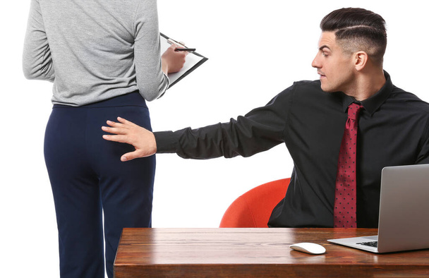 Boss touching butt of his secretary on white background. Concept of harassment - Foto, imagen
