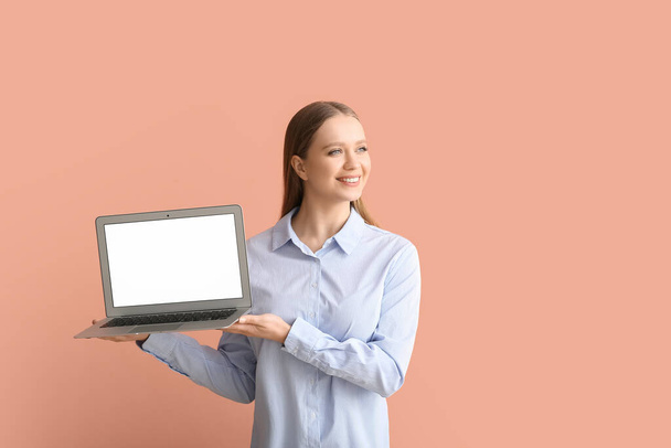 Gyönyörű fiatal nő gazdaság laptop üres képernyő színes háttér - Fotó, kép
