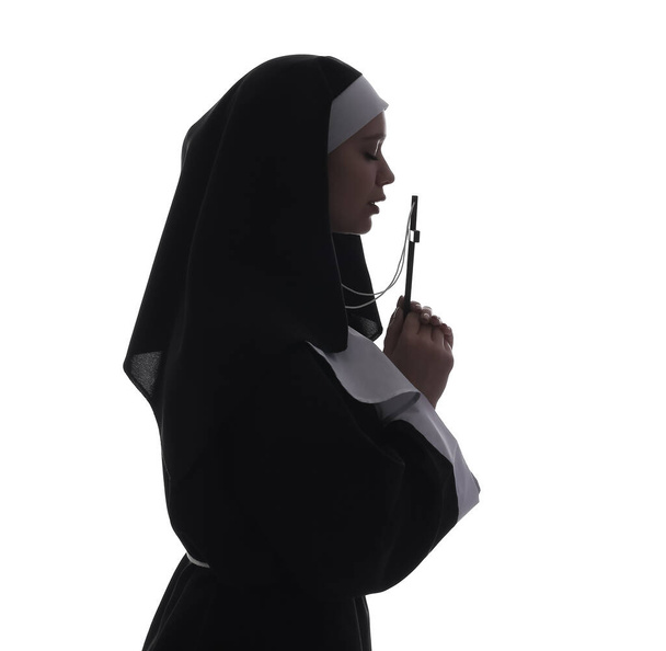 Silhouette einer jungen Nonne mit Kreuz auf weißem Hintergrund - Foto, Bild