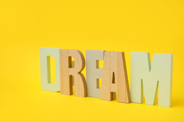 Stylish decor in shape of word DREAM on color background - Foto, Imagen