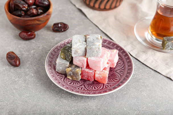 Piatto con dolce delizia turca su sfondo grigio - Foto, immagini