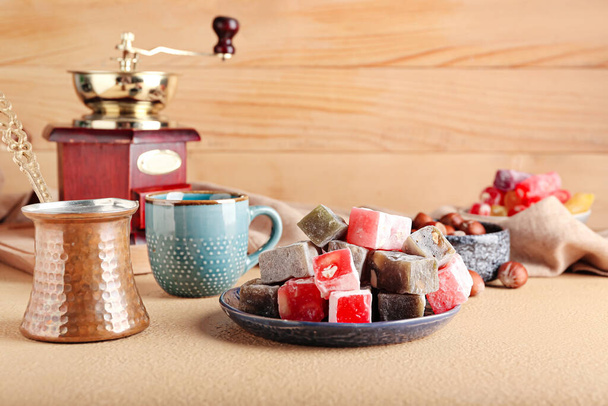 Plate with tasty Turkish delight, coffee pot and cup on table - Photo, Image