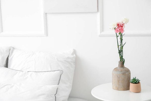 Vaso con bellissimi garofani sul tavolo in camera da letto - Foto, immagini