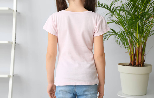 Niña con elegante camiseta en casa, vista trasera - Foto, imagen