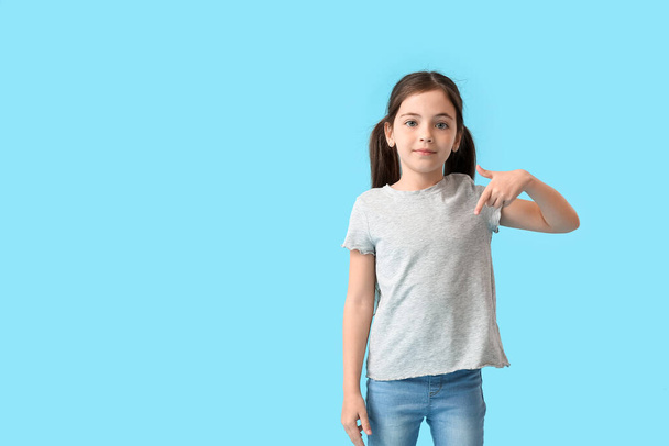 Маленька дівчинка в стильній футболці на кольоровому фоні
 - Фото, зображення
