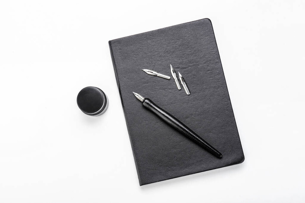 Nib pen with ink and notebook on white background - Фото, изображение