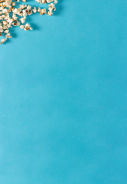 Popcorn on blue background. Flat lay. Copy space. Movie time. - Foto, Bild