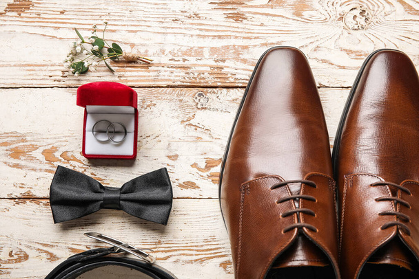 Caja con anillos de boda y accesorios de novio con estilo sobre fondo de madera clara - Foto, imagen