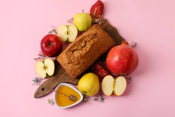 色の背景に蜂蜜、ザクロ、リンゴとパン。ロシュ・ハシャナー（ユダヤの正月）の祝い - 写真・画像