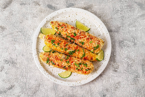 Plate with tasty Elote Mexican Street Corn on grunge background - Foto, immagini